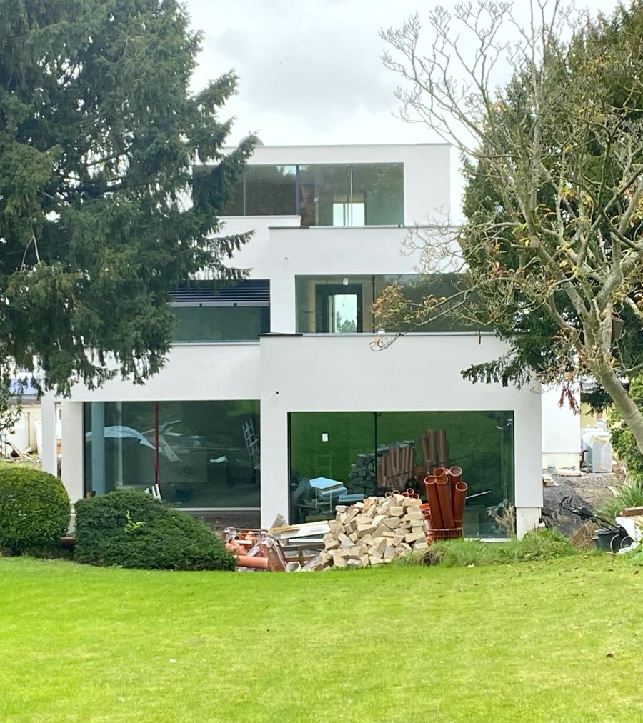 Moderne Villa mit rahmenlosen superview Glasfronten über drei Ebenen